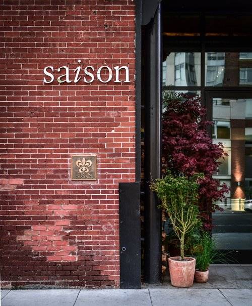 Exterior View of Saison Restaurant with Red Brick Wall and Potted Plants